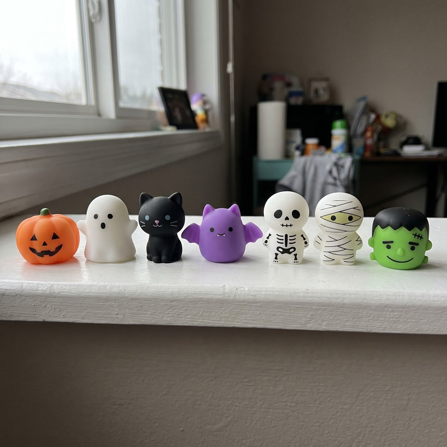 Seven Halloween squishies lined up on a windowsill